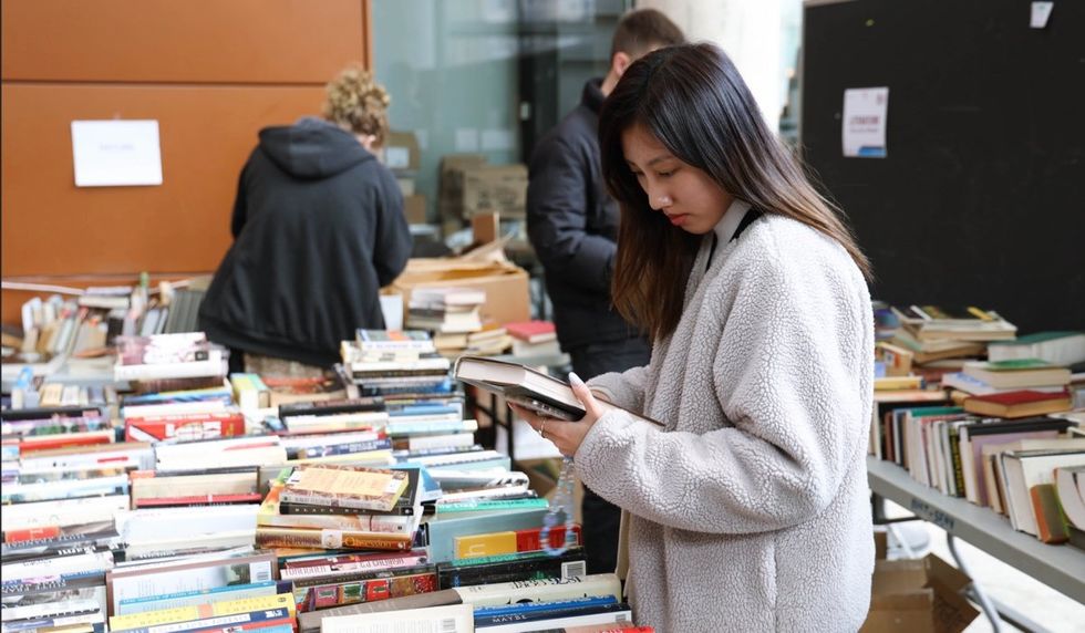 A person looking through the books at Concordia's used book sale.