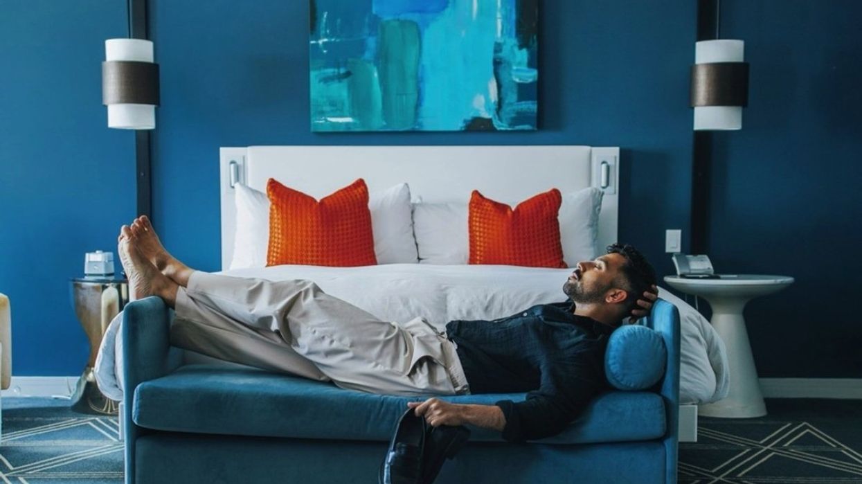 A person lying down on a sofa in their hotel room at the Fairmont Queen Elizabeth in Montreal, Quebec.