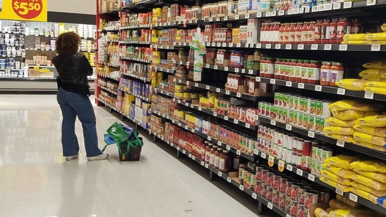 A person standing in a grocery aisle in Canada doing their grocery shopping.