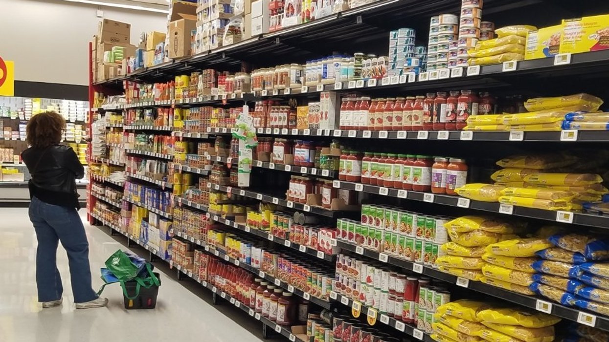 A person standing in a grocery aisle in Canada doing their grocery shopping.