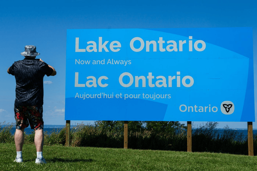 A person takes a picture of the newly unveiled sign for Lake Ontario.