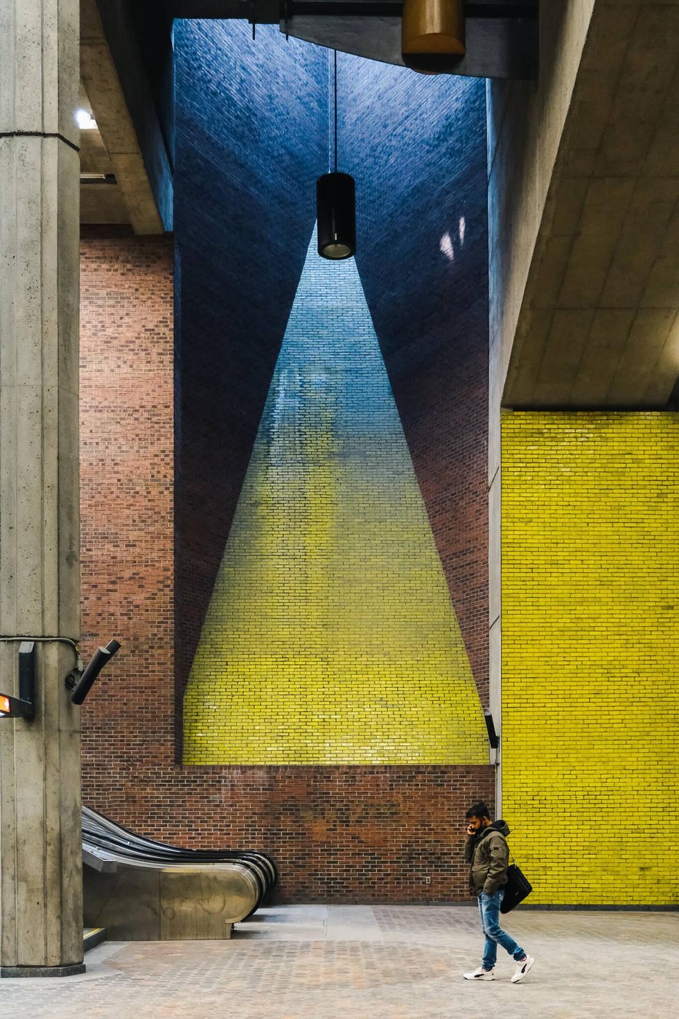 A person talks on a cellphone inside Place Saint-Henri station on the Montreal metro.