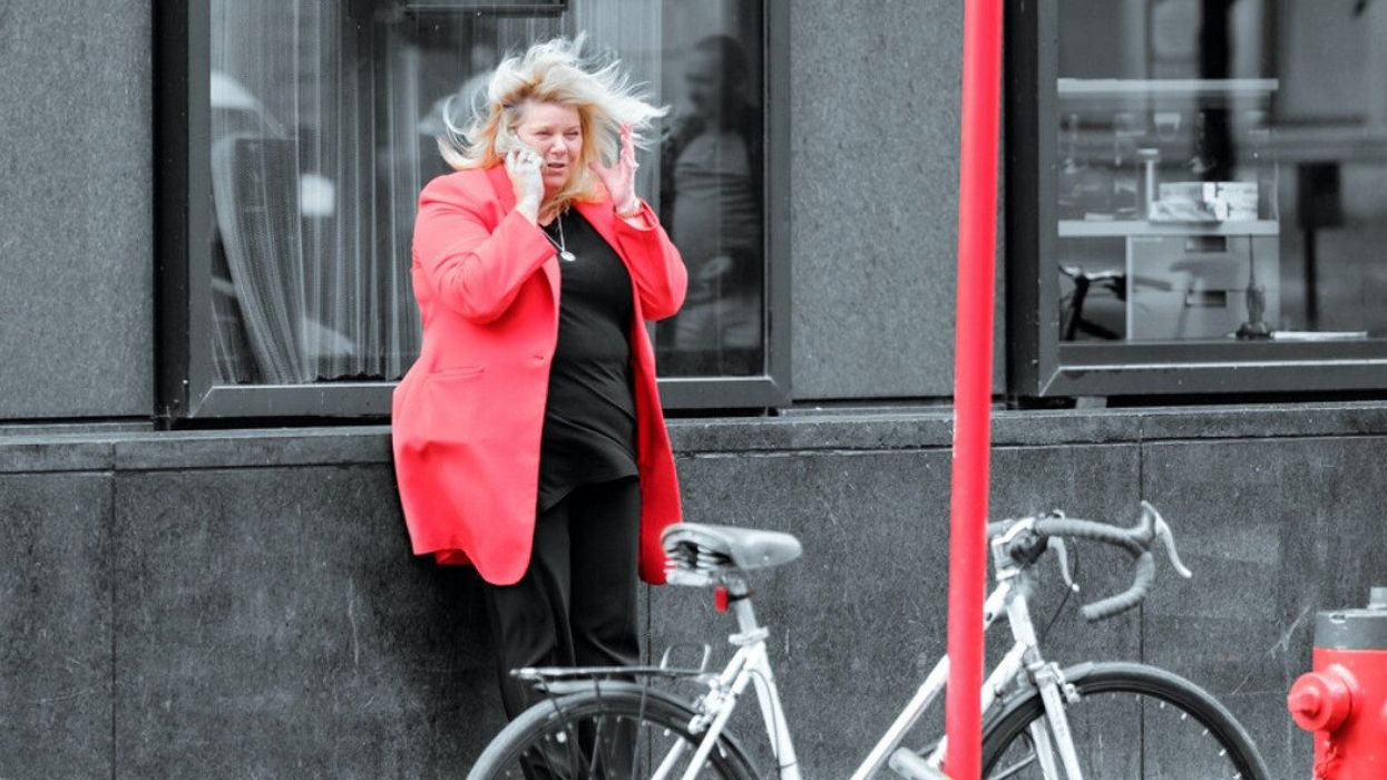 A person tries to have a phone conversation on a windy street in Montreal.