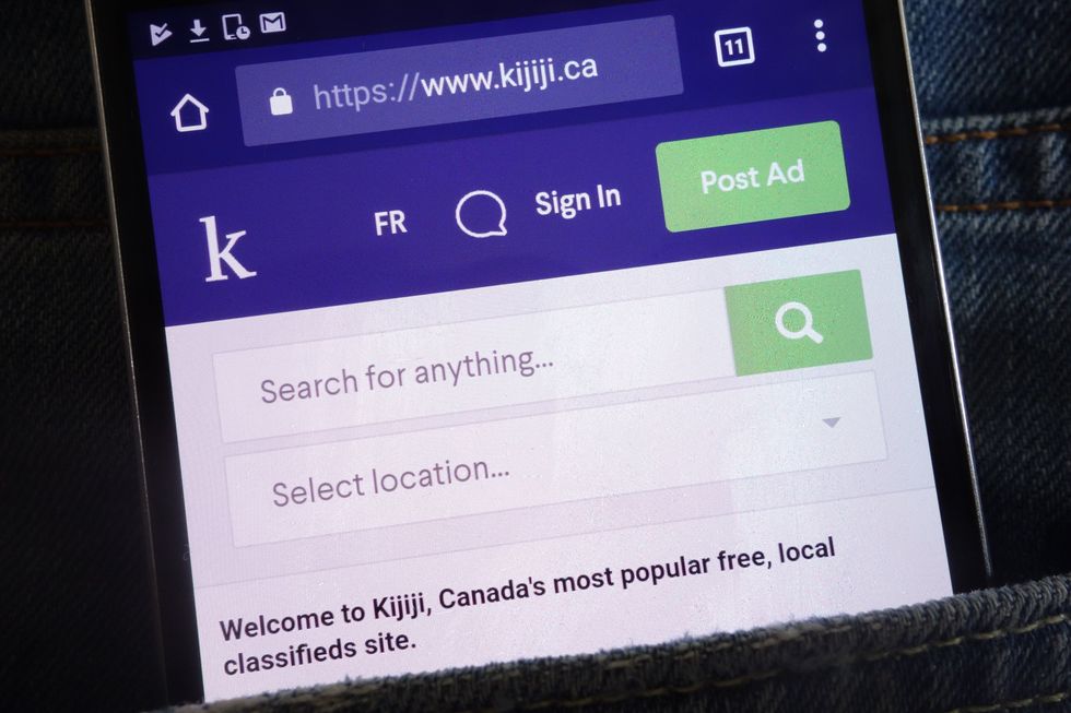 A phone with the Kijiji website open peeks out of someone's pocket.