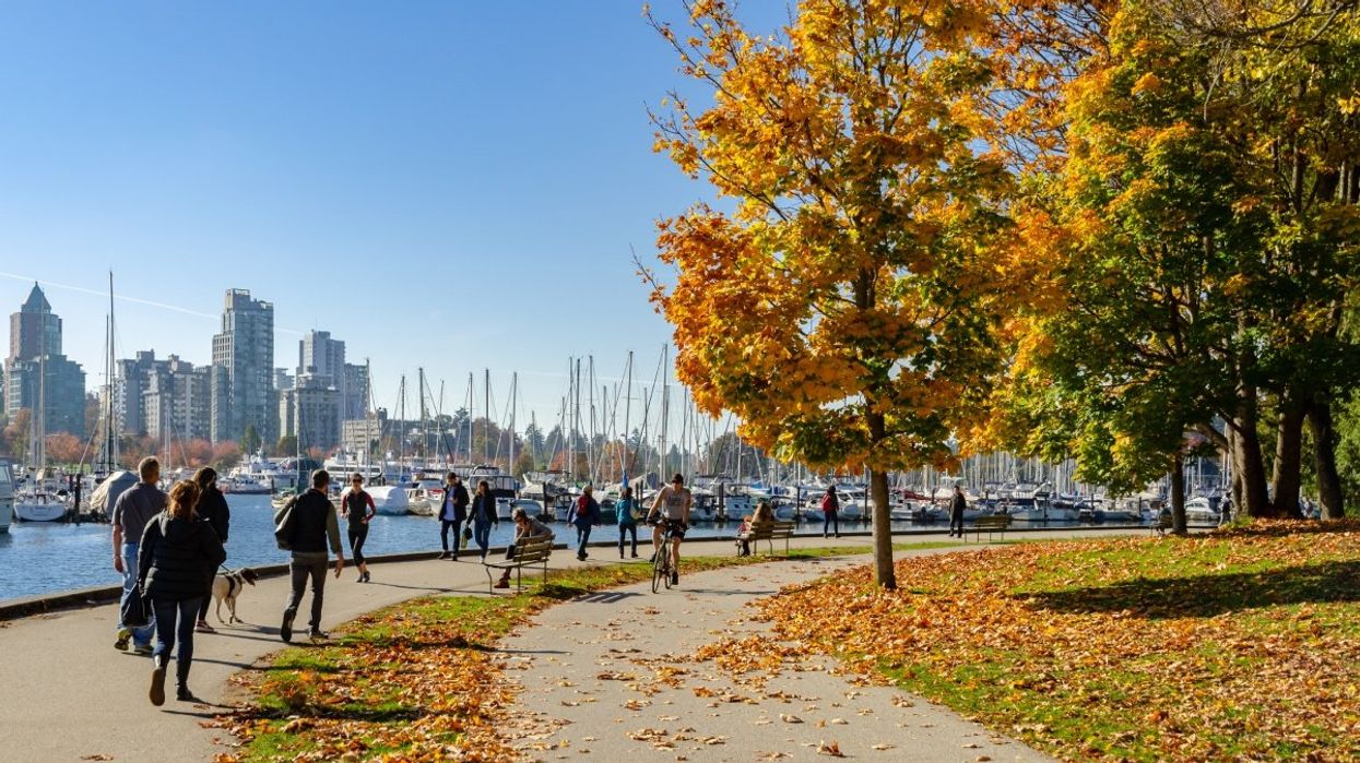 A photo of pedestrians and bikers walking the Stanley Park Seawall during the fall in Vancouver, British Columbia.