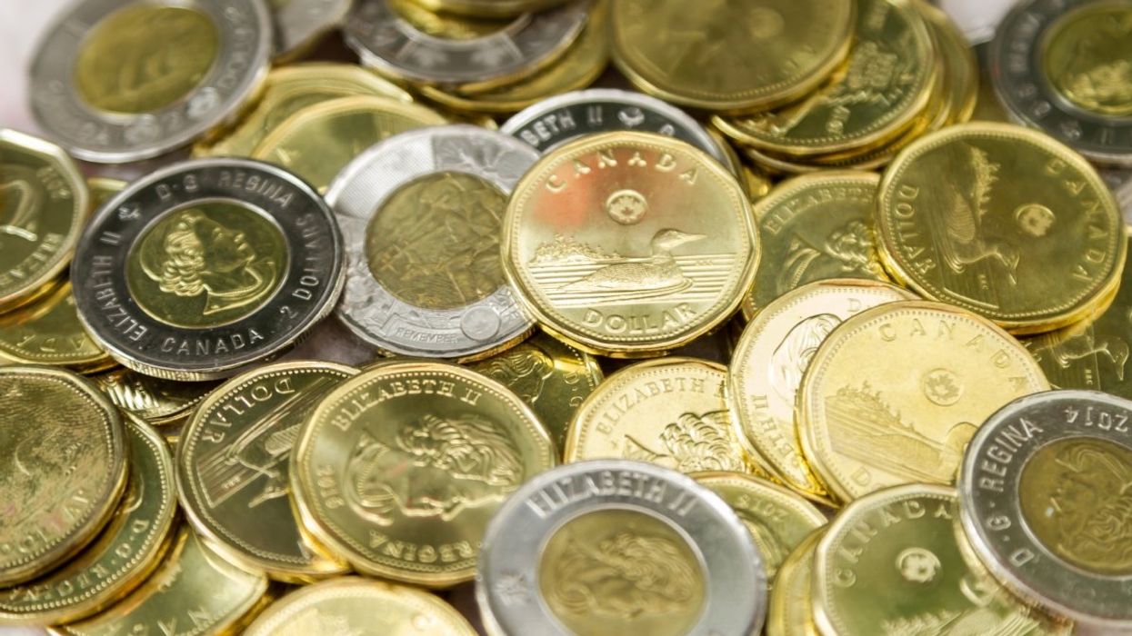 A pile of Canadian $1 coins (loonies) and $2 coins (toonies).