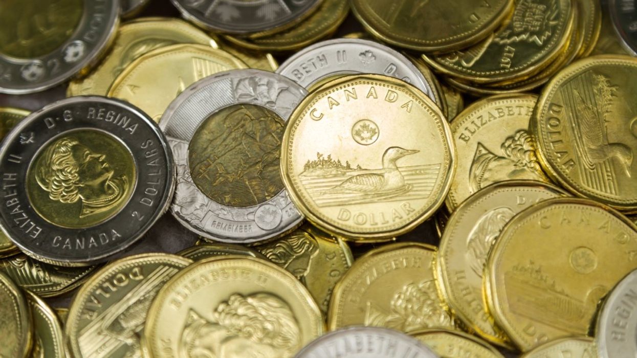 A pile of Canadian $1 dollar coins (loonie) and $2 dollar coins (toonie).