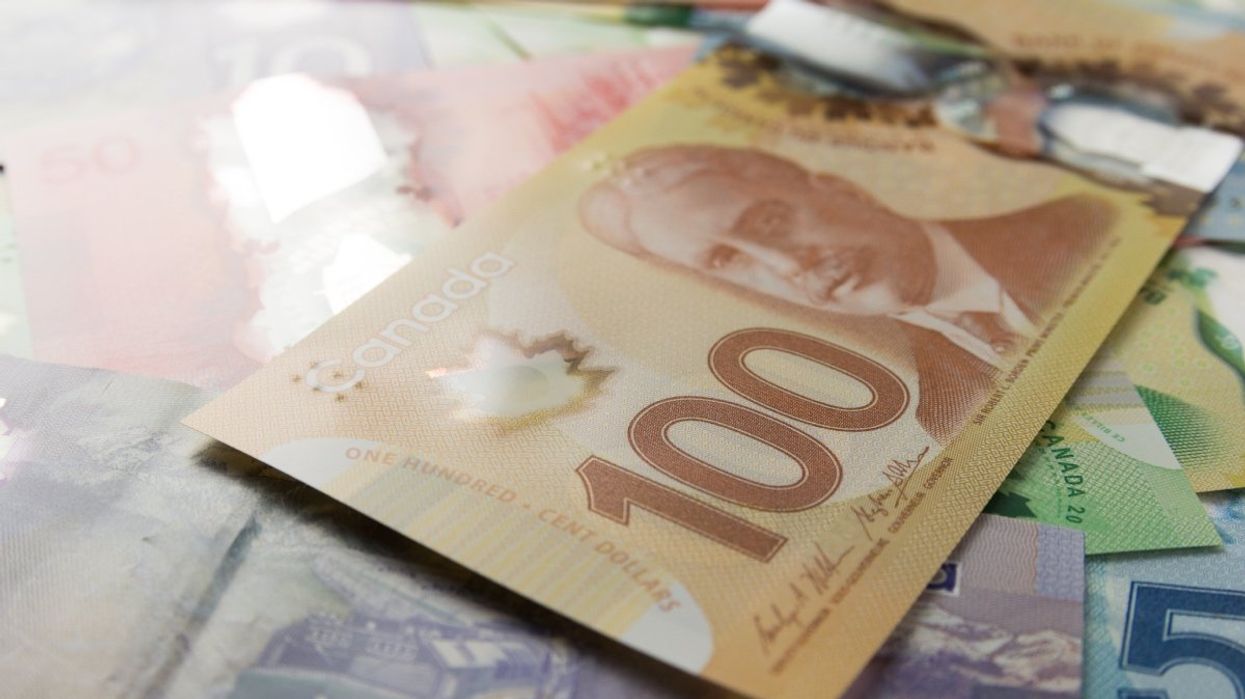 A pile of Canadian banknotes with a $100 bill front and centre.