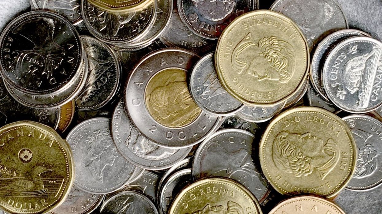 A pile of Canadian coins including $1 coins (loonies), a $2 coin (toonie), and Canadian dimes, nickels and the discontinued penny.