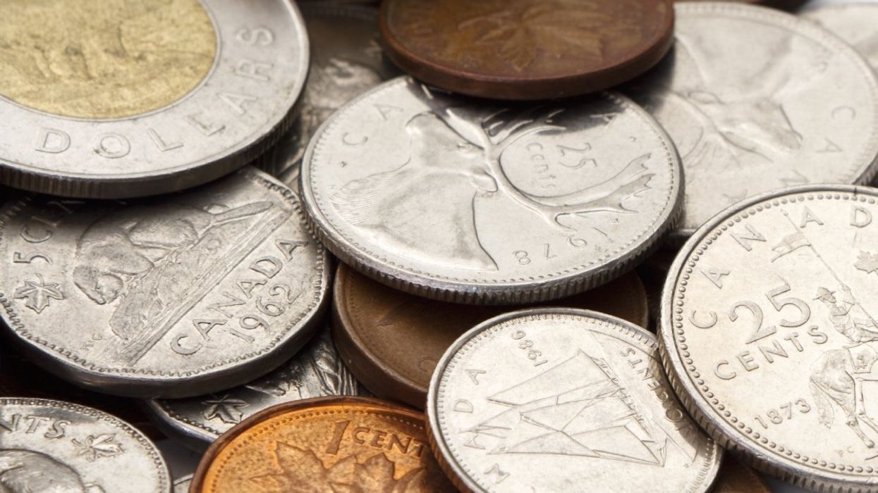 A pile of Canadian coins including a loonie ($1 coin), toonie ($2 coin), quarters, dimes and nickels.