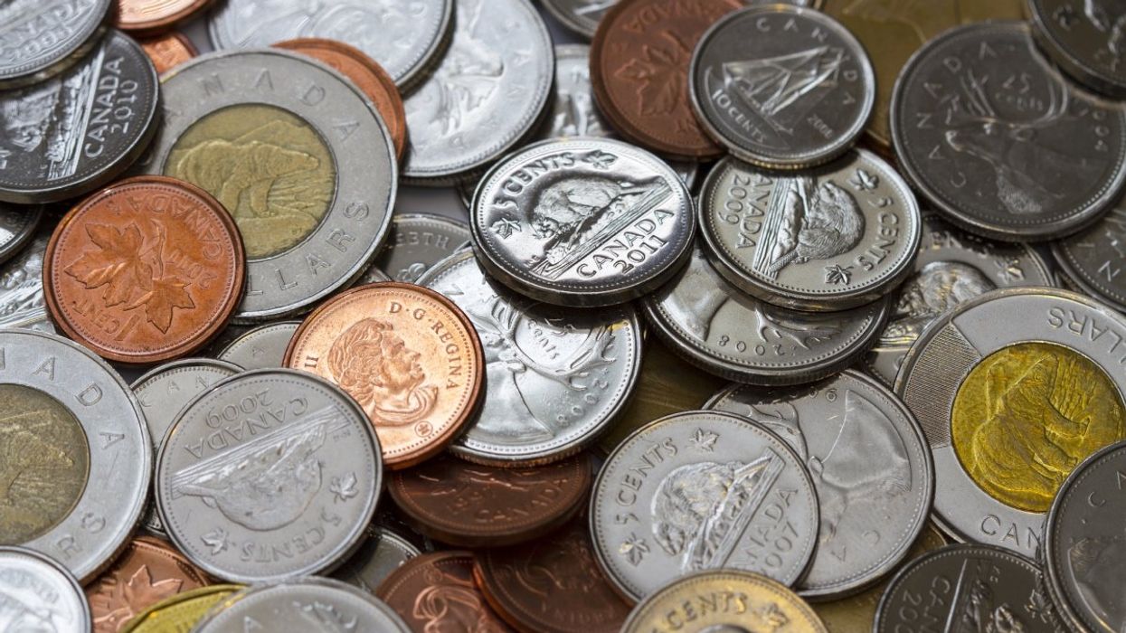 A pile of Canadian coins including a loonie ($1 coin), toonie ($2 coin), quarters, dimes and nickels.