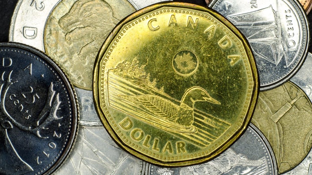 A pile of Canadian coins including a loonie ($1 coin), toonies ($2 coins), nickels, dimes and quarters.