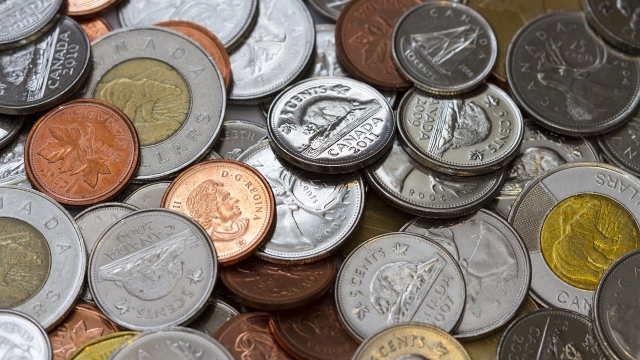 A pile of Canadian coins including loonies, toonies, quarters, dimes, nickels and pennies.