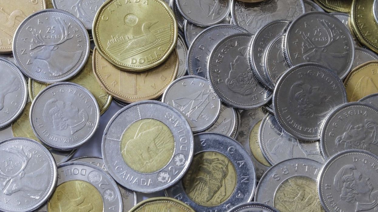 A pile of Canadian coins including several toonies ($2 coins), loonies ($1 coins), quarters, dimes and nickels.