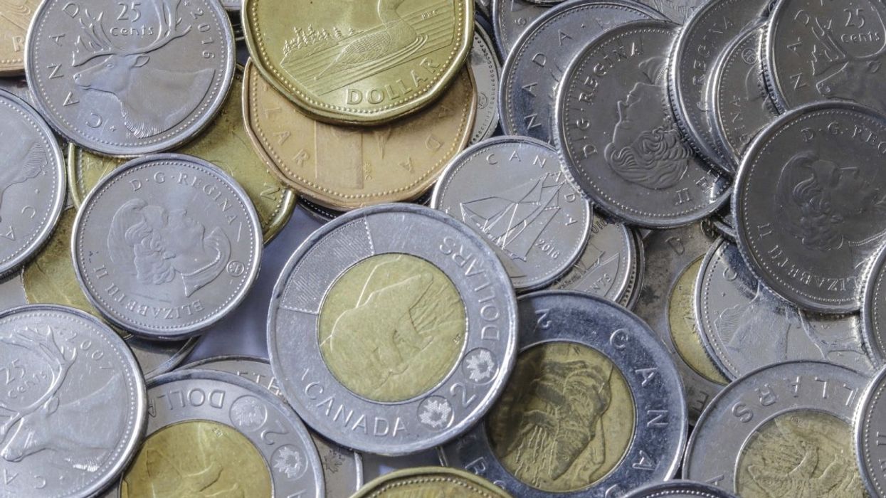 A pile of Canadian coins including toonies ($2 coin), loonies ($1 coin), quarters, nickels and dimes.