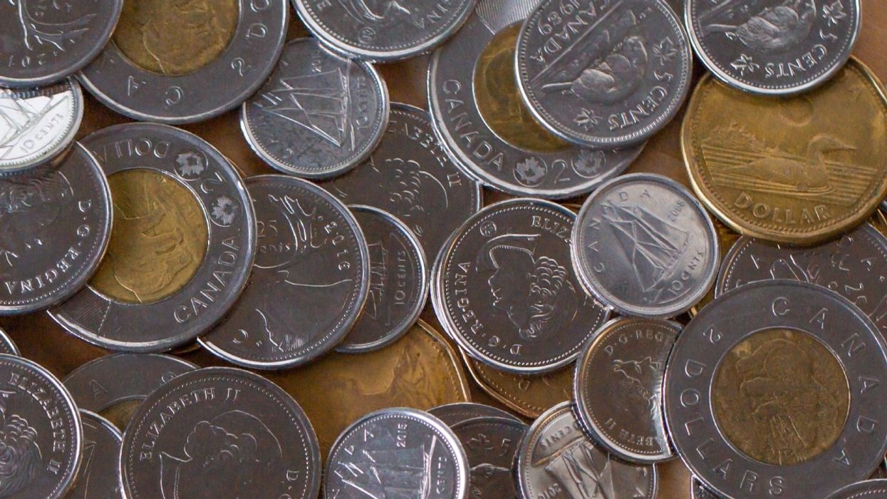 A pile of Canadian coins including toonies ($2 coins), loonies ($1 coins), quarters, dimes, nickels, and discontinued pennies.
