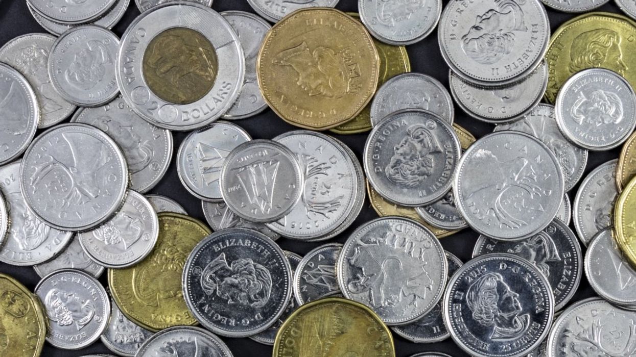A pile of Canadian coins made up of toonies ($2 coin), loonies ($1 coins), quarters, nickels and dimes.