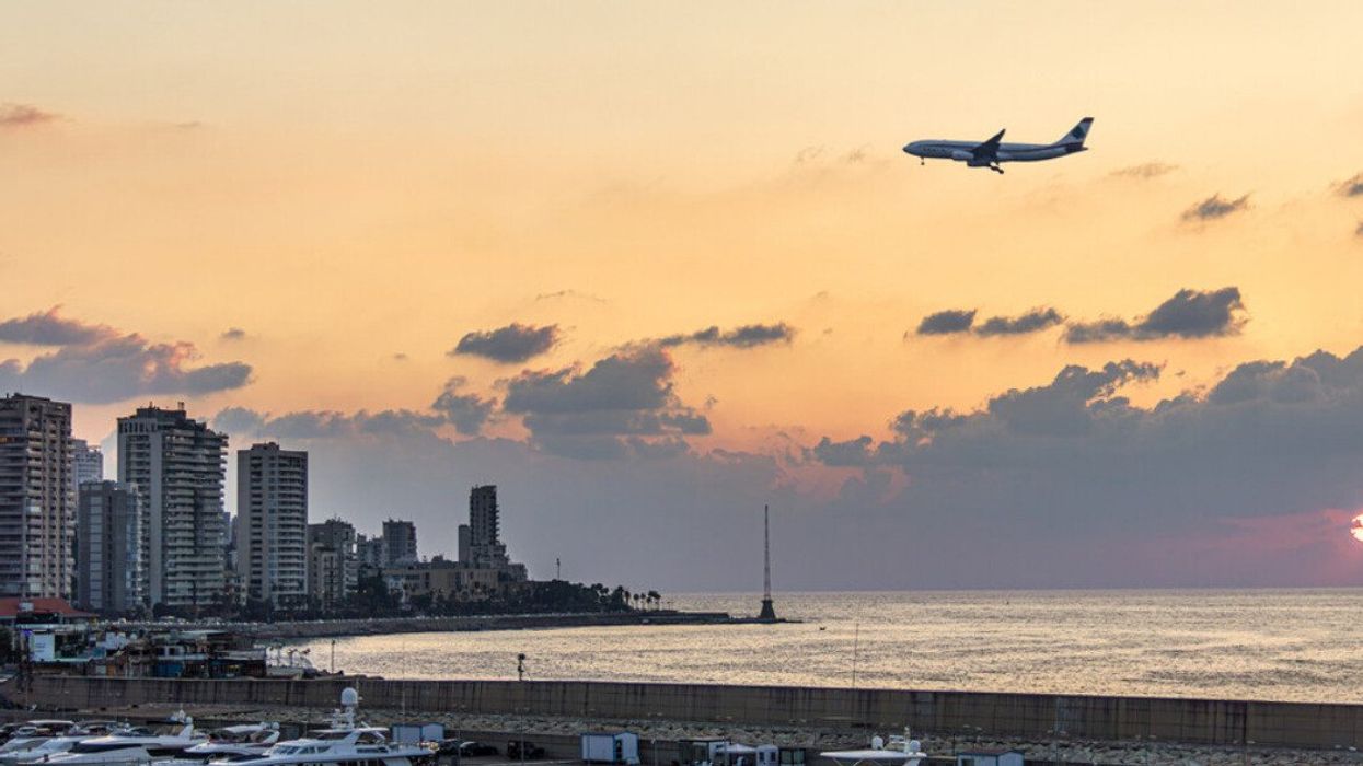 A plane at dusk over the Beirut waterfront.