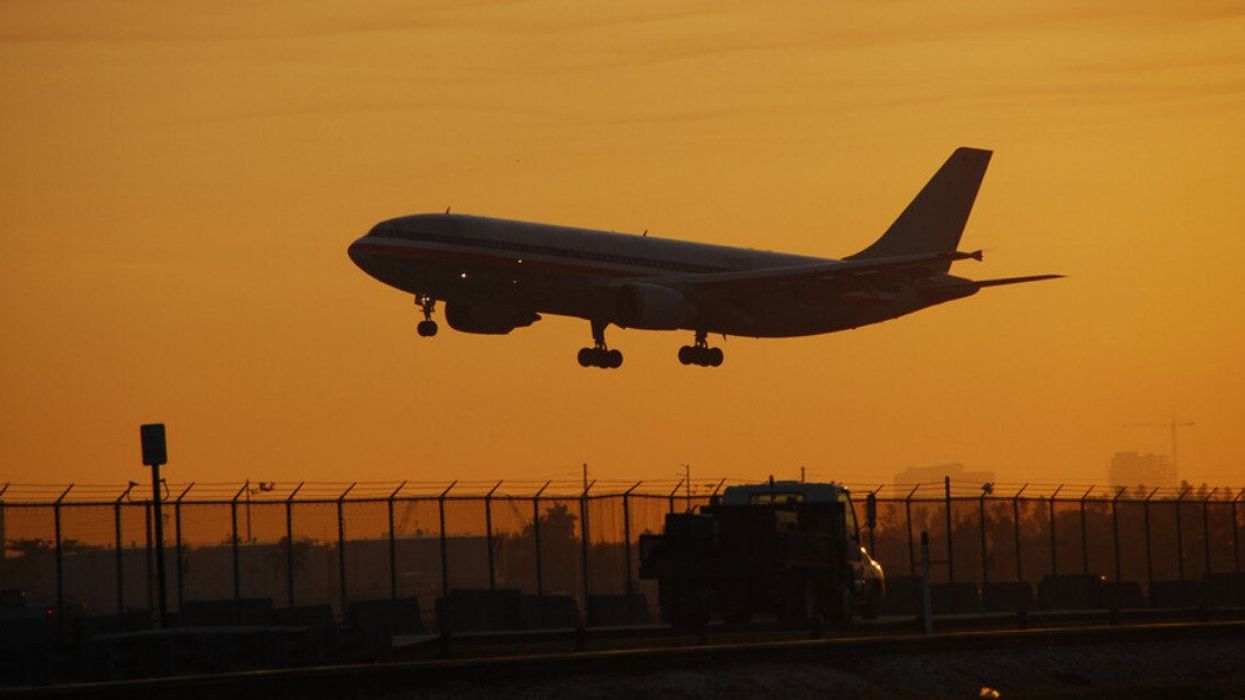 A plane landing at dusk.
