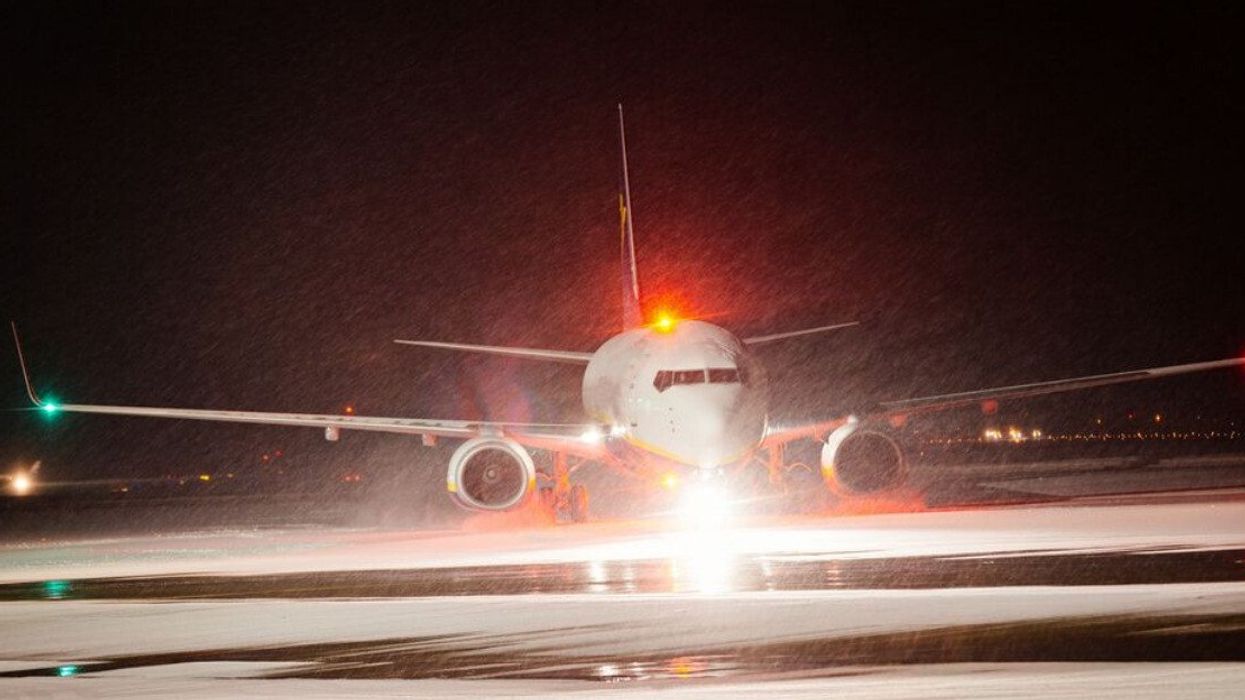 A plane landing in snowy weather.