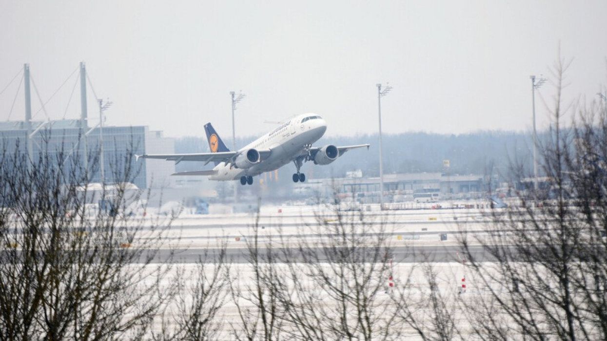A plane taking off from the airport in Munich during winter.
