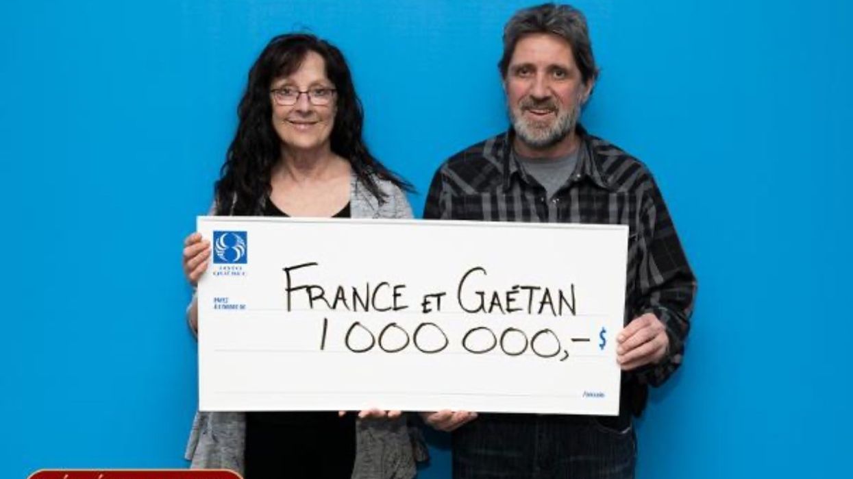 A Quebec couple posing with a $1 million cheque after winning the Celebration 2023 lottery.