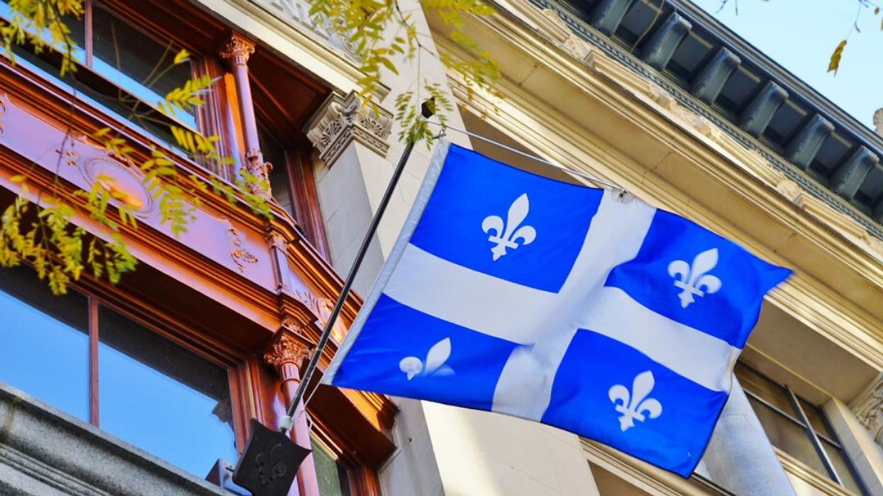 A Quebec flag on display, hanging outside a Montreal building.