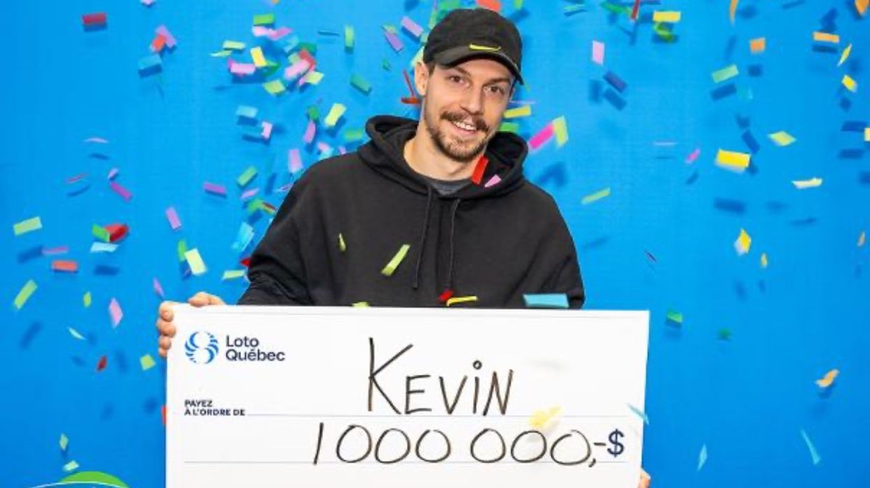 A Quebec resident holding a massive cheque for $1,000,000 at the Loto-Québec headquarters.