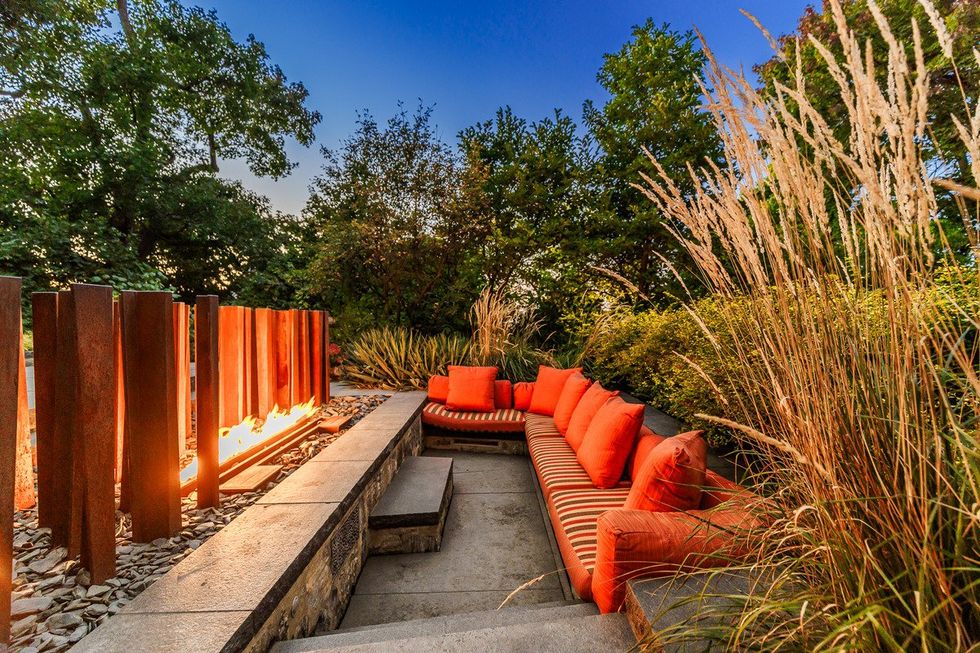 A recessed seating area on the back patio, by the outdoor fire pit.