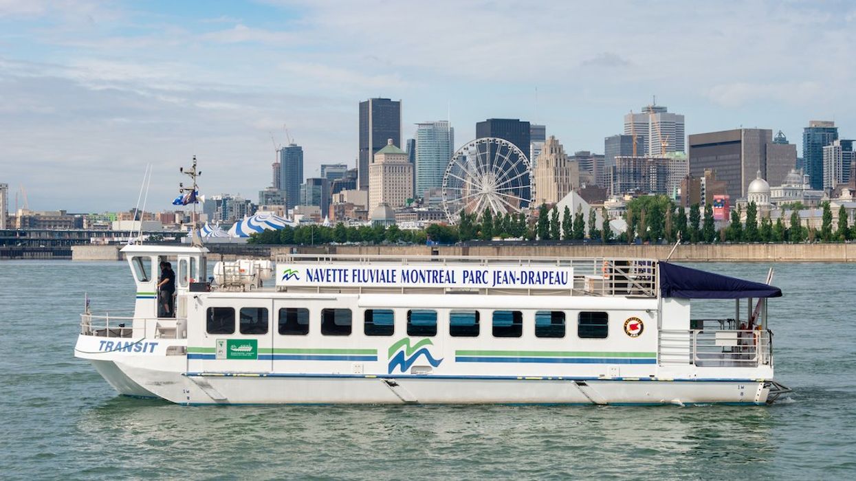 A river shuttle travelling between the Montreal Old Port and Île Sainte-Hélène, with the downtown Montreal skyline visible in the background.