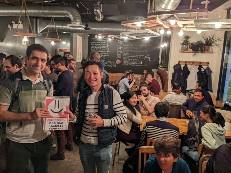 A room full of people mingling and drinking together. \u200b