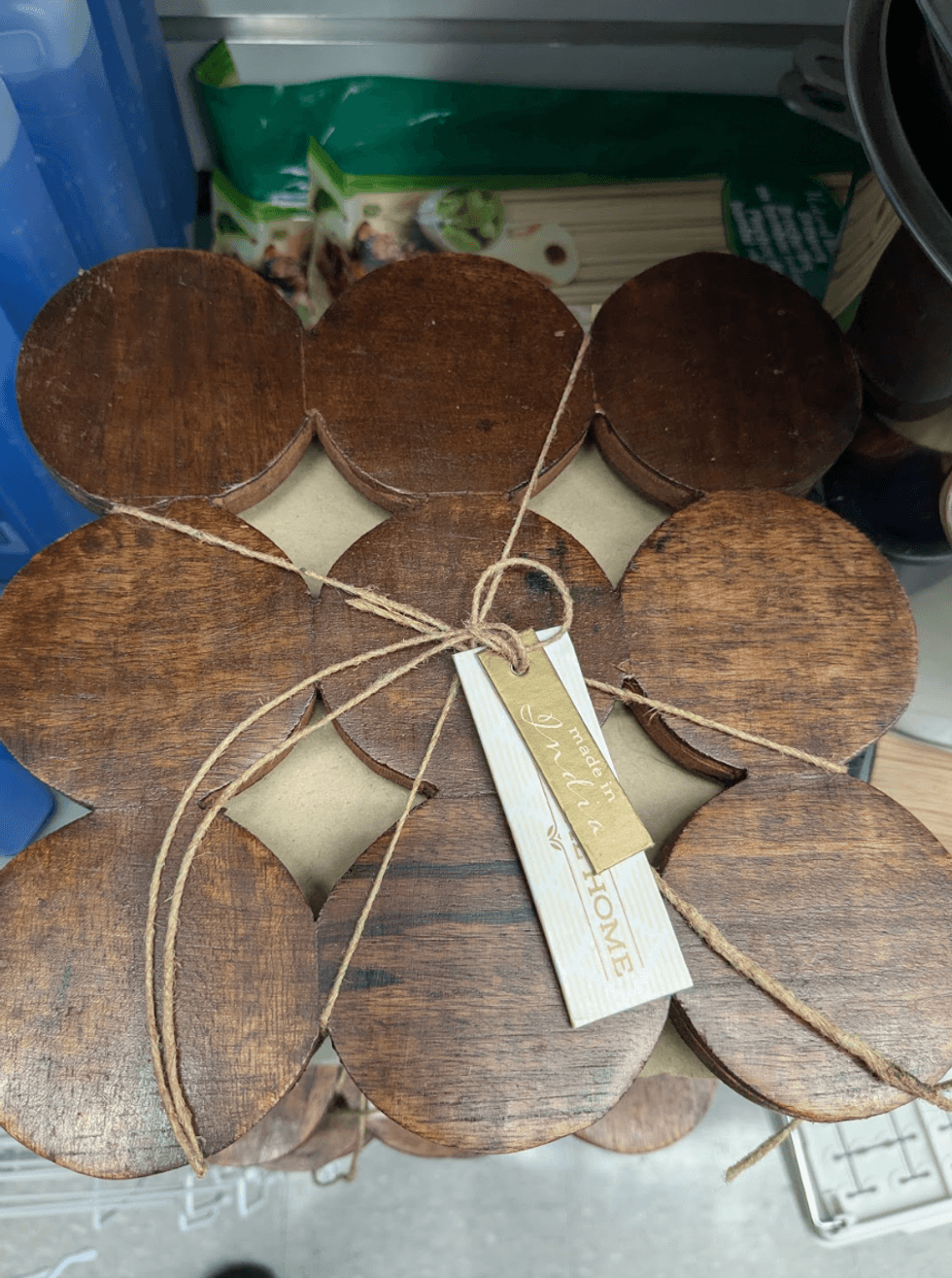 A round wooden trivet with a geometric cut-out pattern on a counter