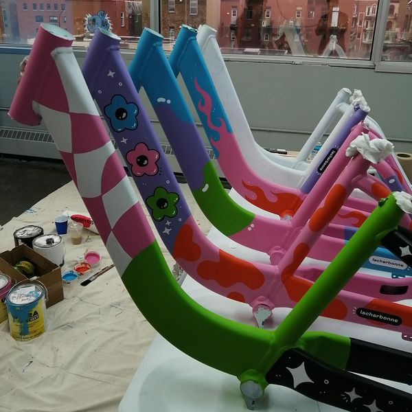 A selection of five BIXI bike frames painted by La Charbonne, featuring funky patterns like stars, flowers and flames.