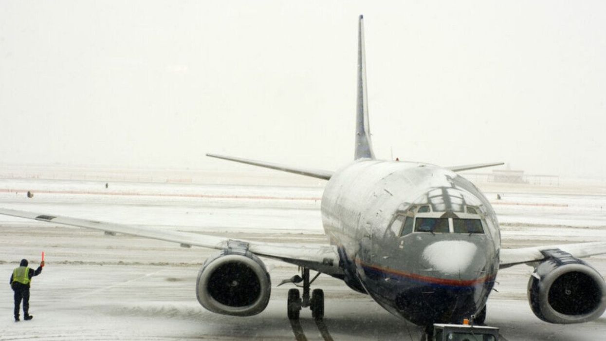 A snow-covered plane on an airport tarmac.