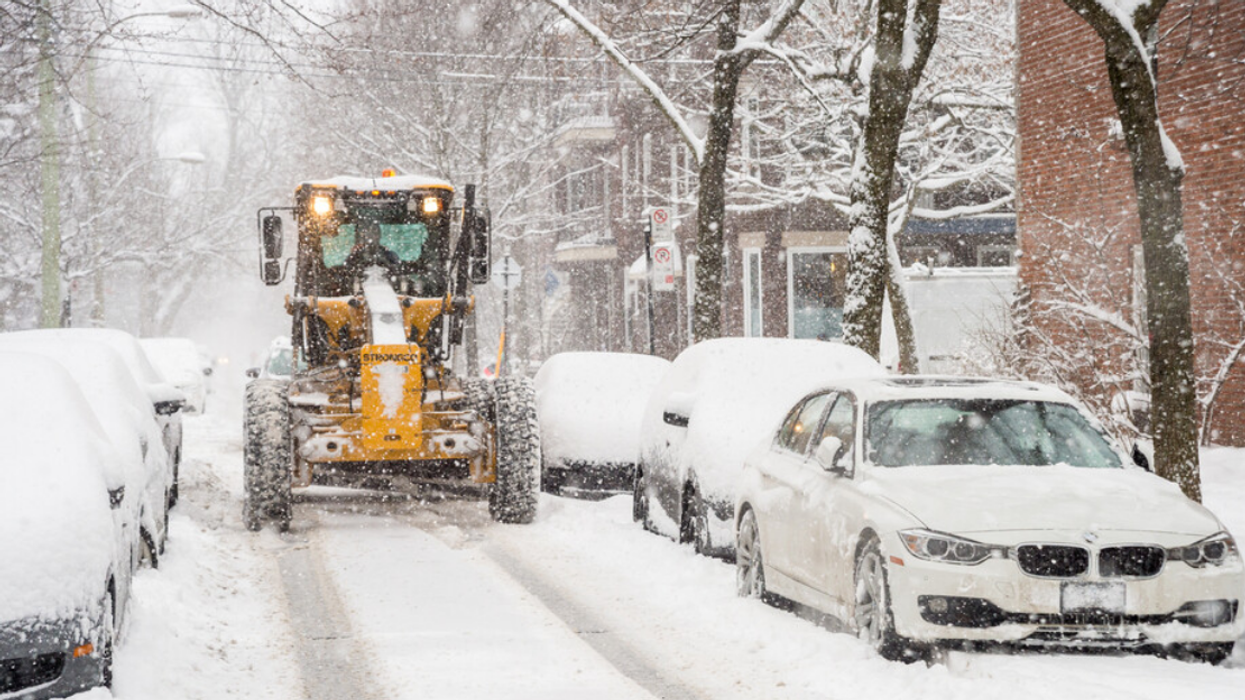 A snowplow clears a Montreal street in winter.