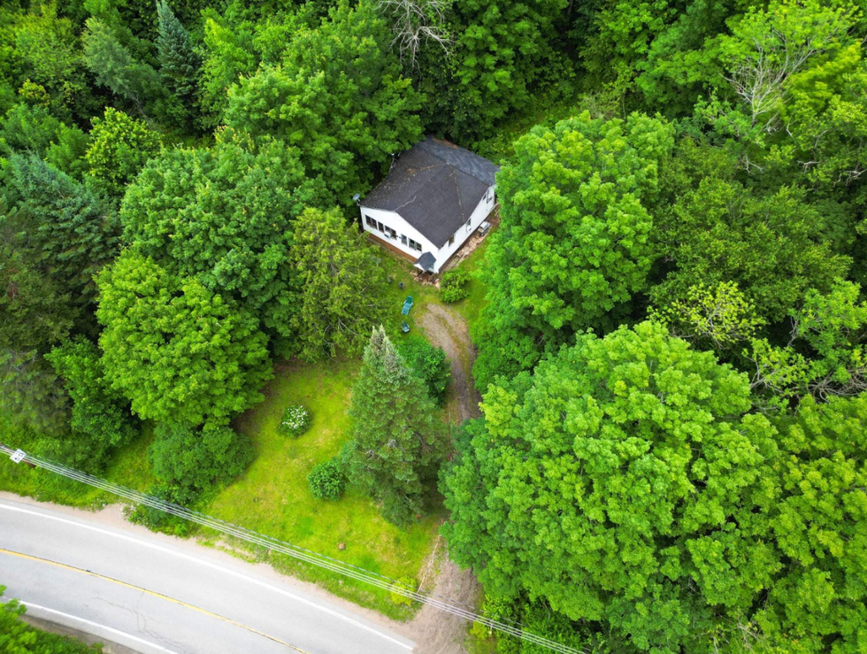 A square house surrounded by forest.