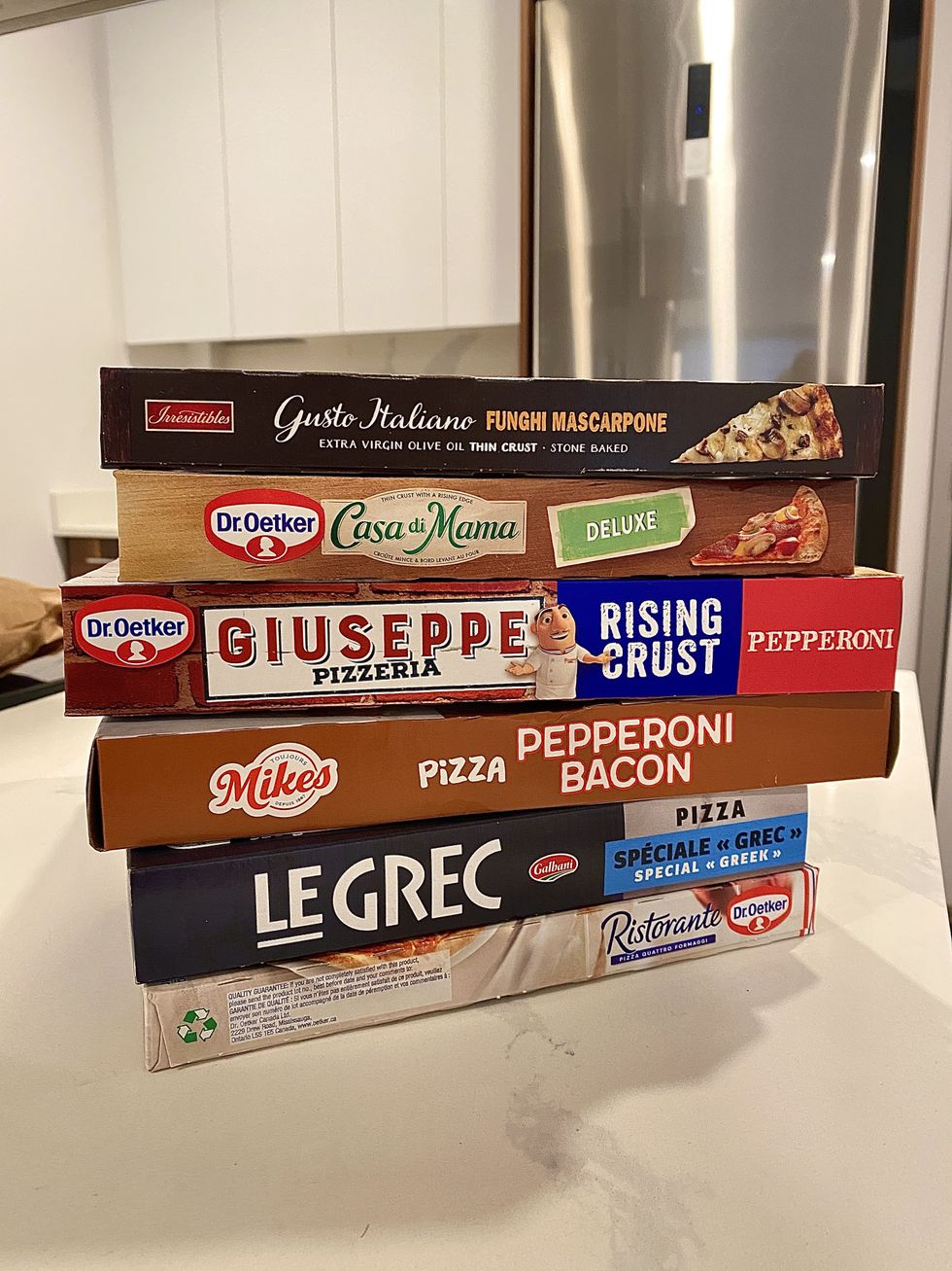 A stack of frozen boxed pizzas.