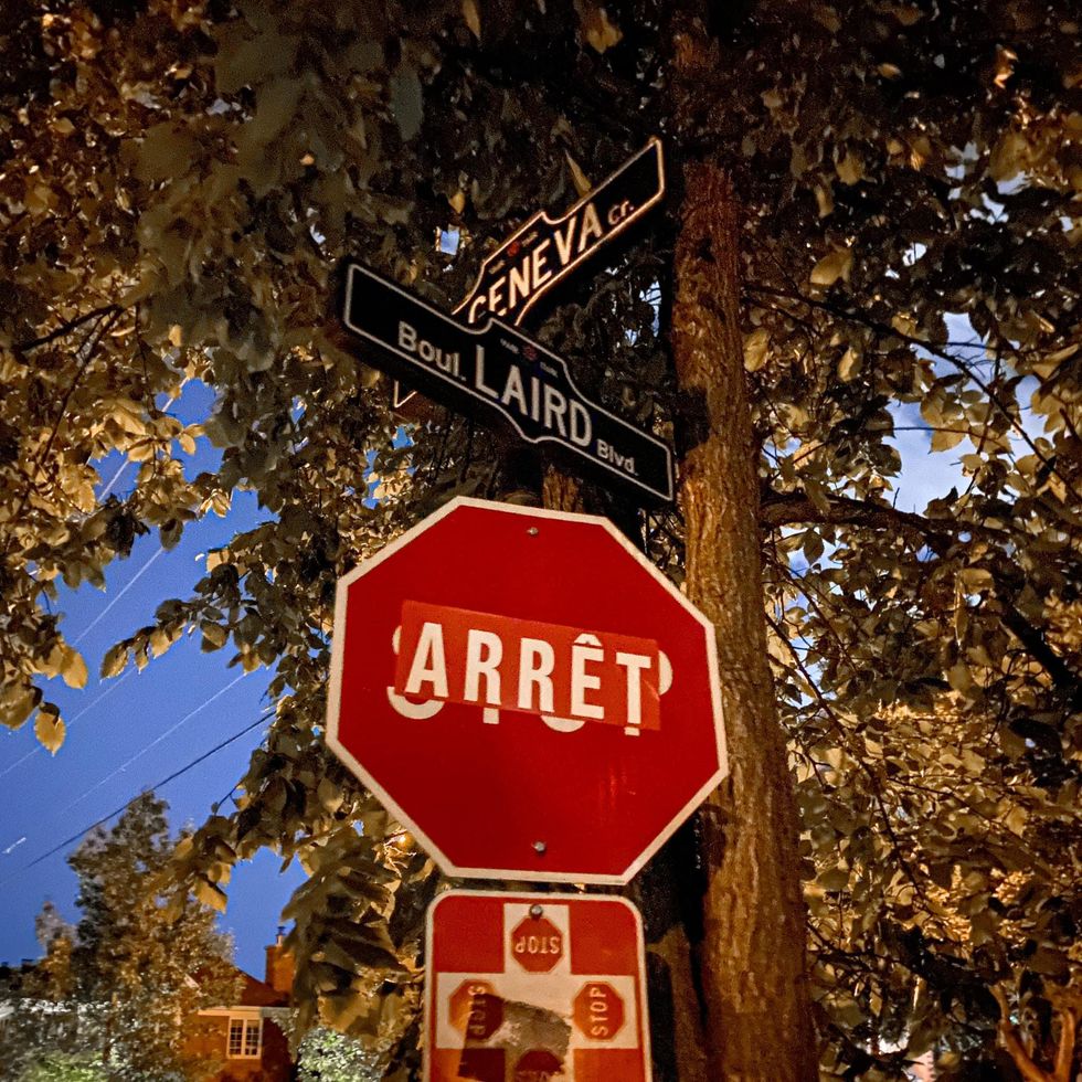 A "STOP" sign covered with an "ARR\u00caT" sticker.
