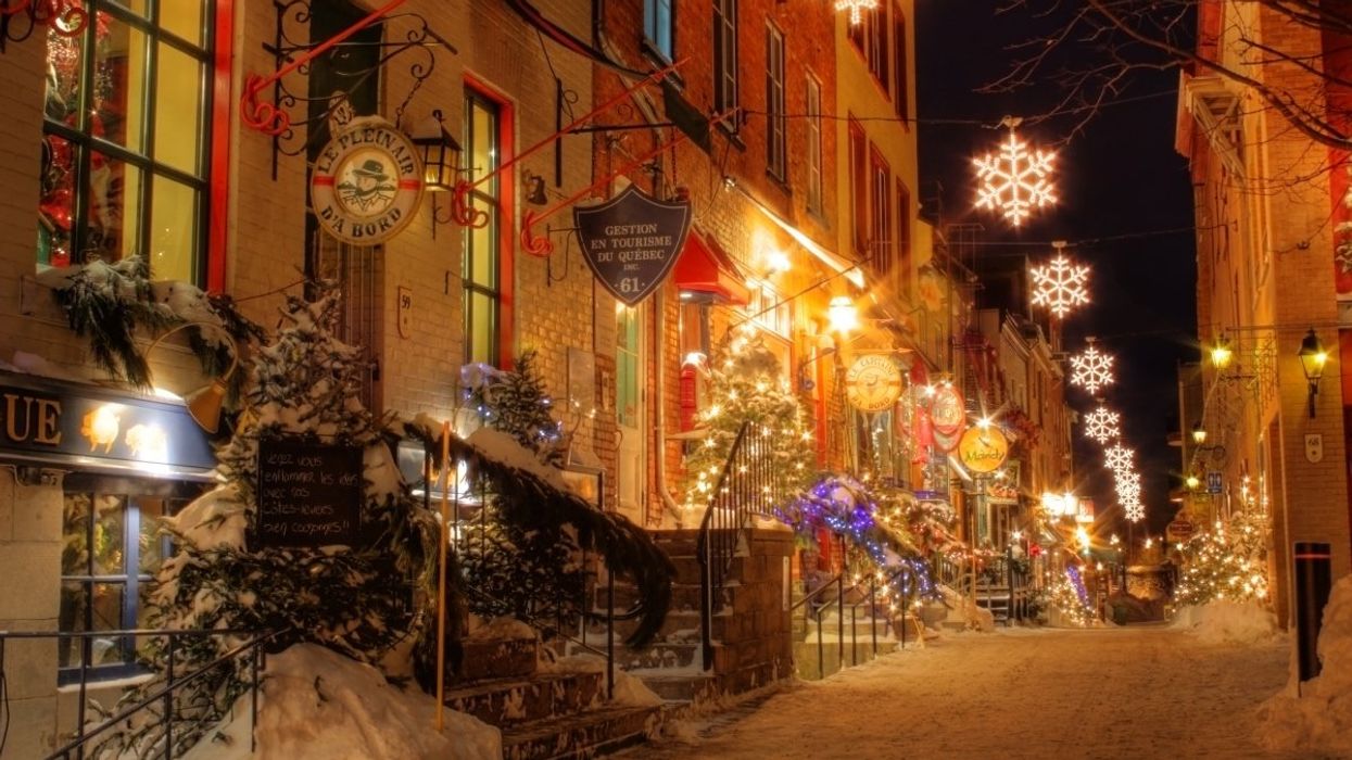 A street in the Old Town of Quebec City lit up with holiday lights during Christmas.