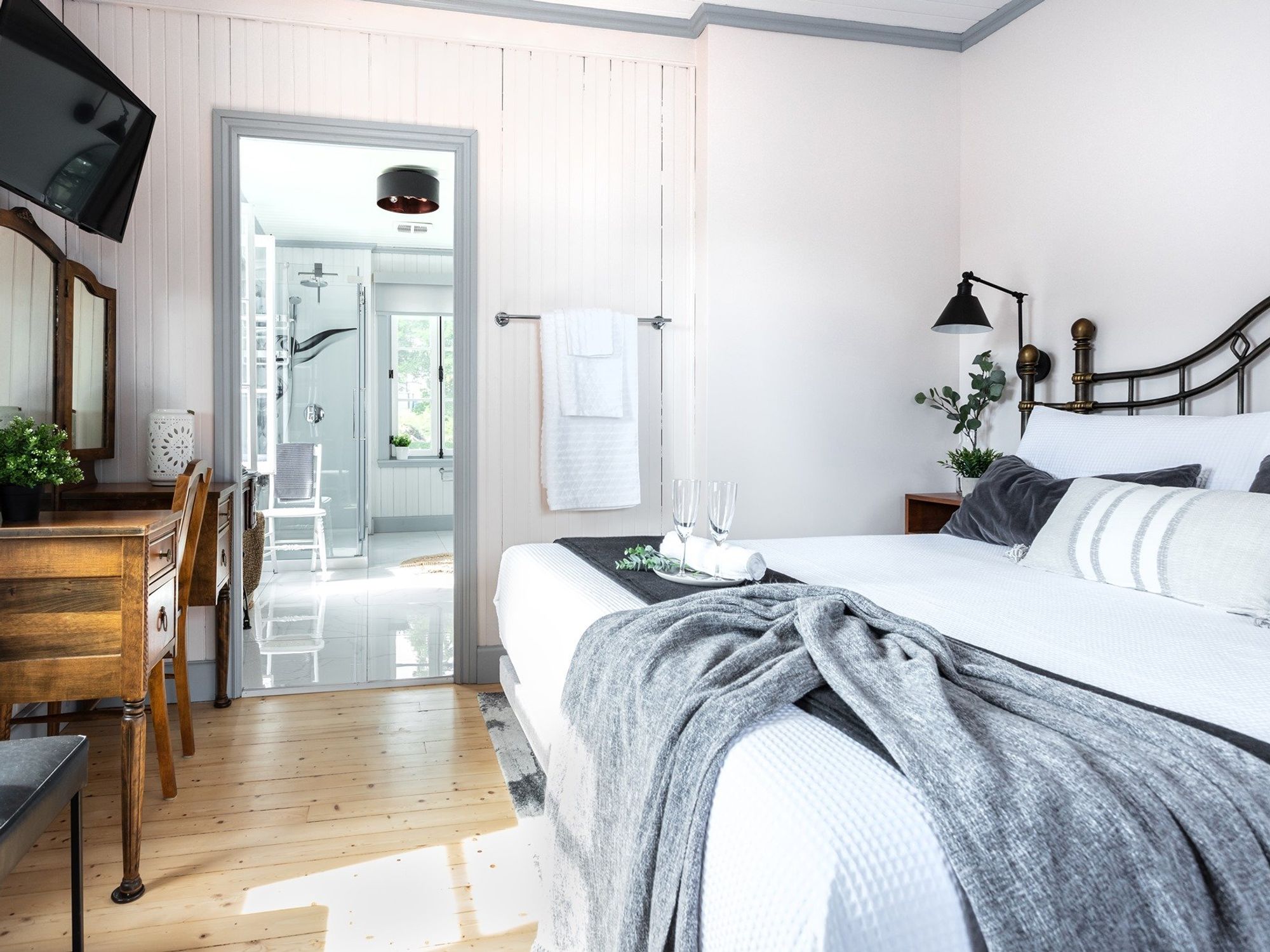 A sun-drenched room with a Queen-sized cast iron bed and shabby chic decor.