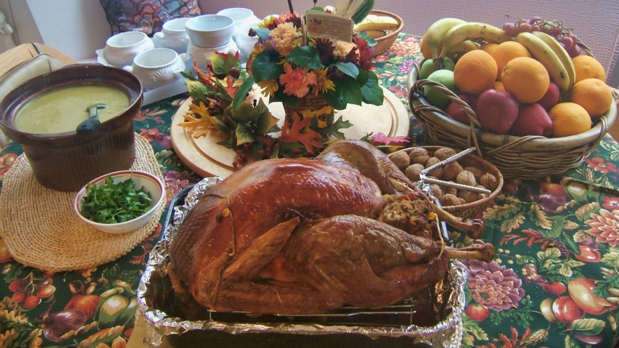 A typical Canadian Thanksgiving dinner with soup, turkey, and stuffing on a autumn-themed table.