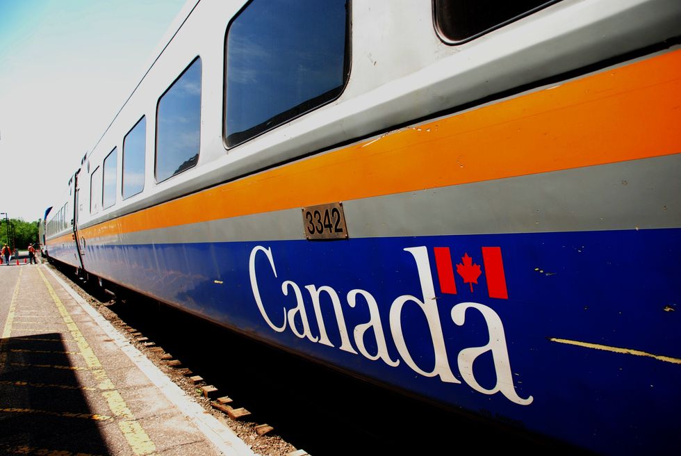A VIA Rail train with a Canada logo on the side.