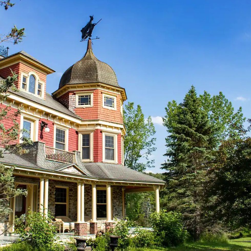 A Victorian home with a witch weathervane.
