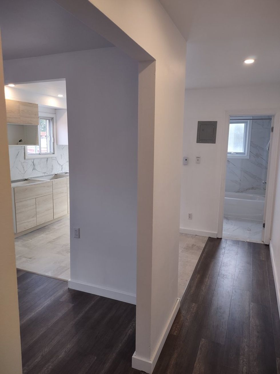 A view down the central corridor toward the kitchen and bathroom in an apartment for rent at 10380, avenue des R\u00e9collets.