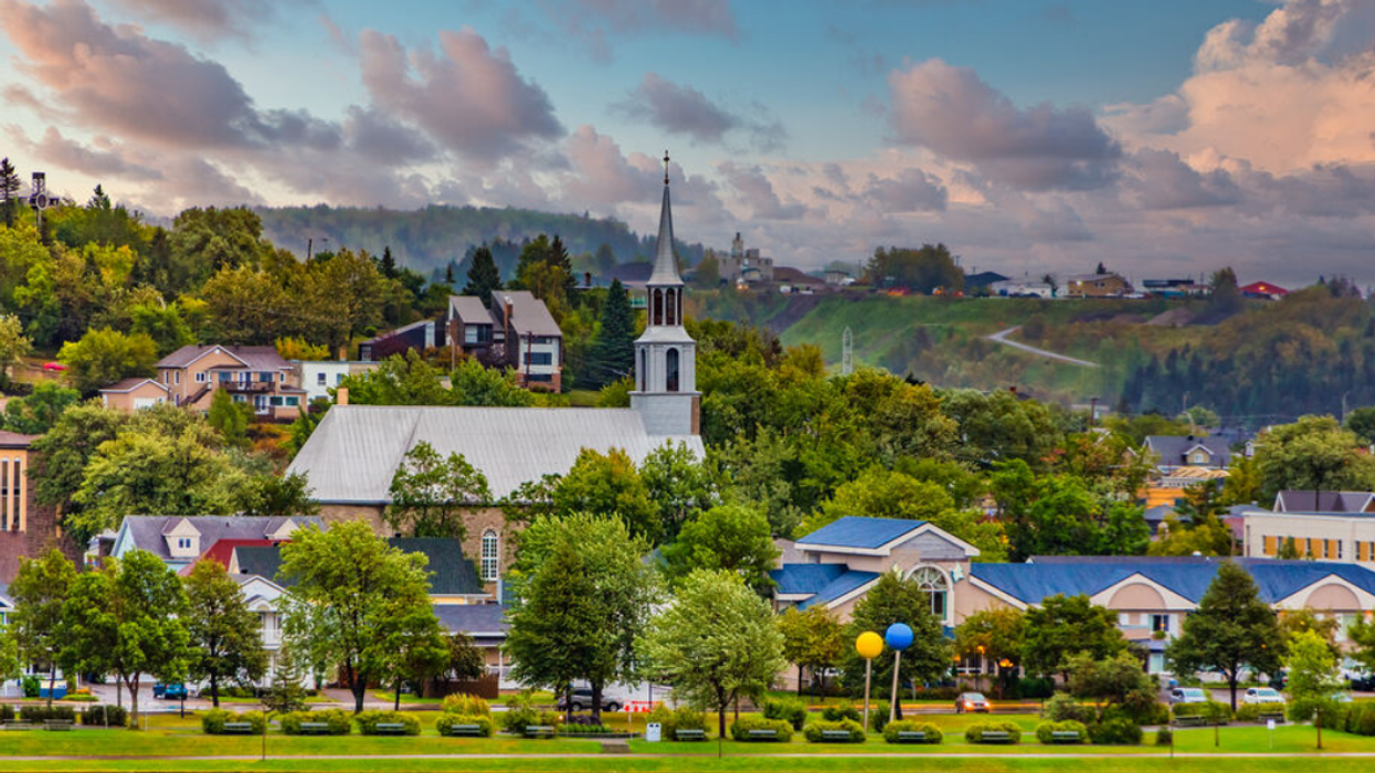 A view of a church surrounded by houses in Saguenay.
