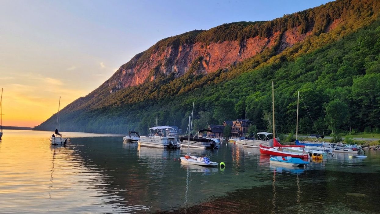 A view of Lake Willoughby in Vermont with the sun setting across the mountaintop.