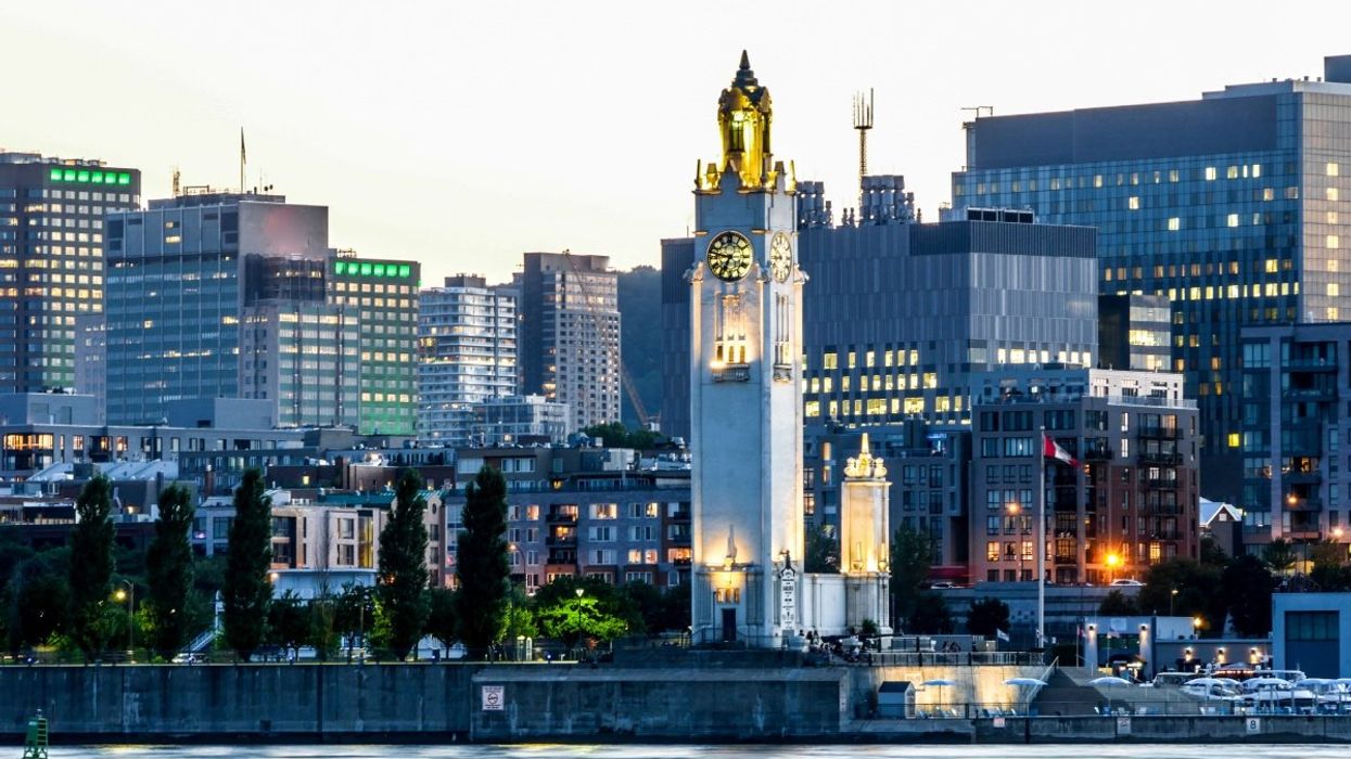 A view of Montreal's downtown skyline and Old Ports Clock Tower at sunset.