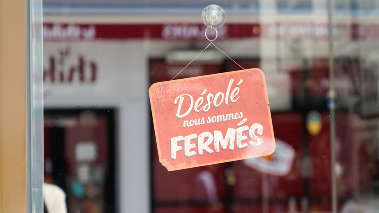 A vintage red panel shop sign reads, "Désolé nous sommes Fermés," which in English means "Sorry we're closed."
