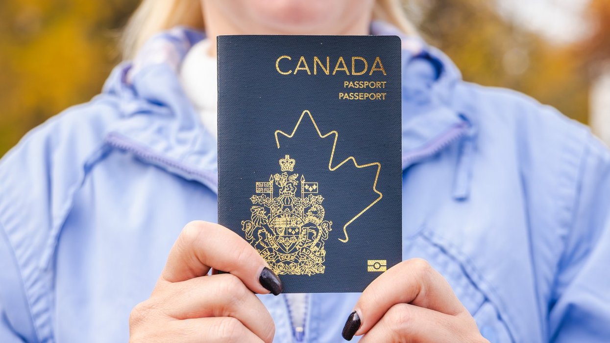 A woman holding a Canadian passport.