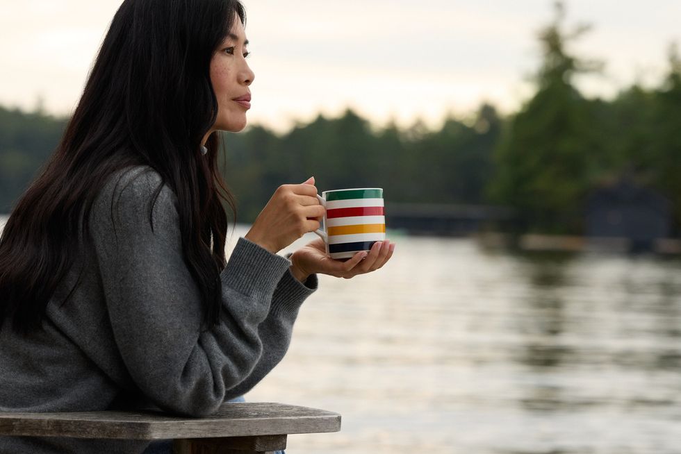 Una mujer sosteniendo una taza de café de la Bahía de Hudson.